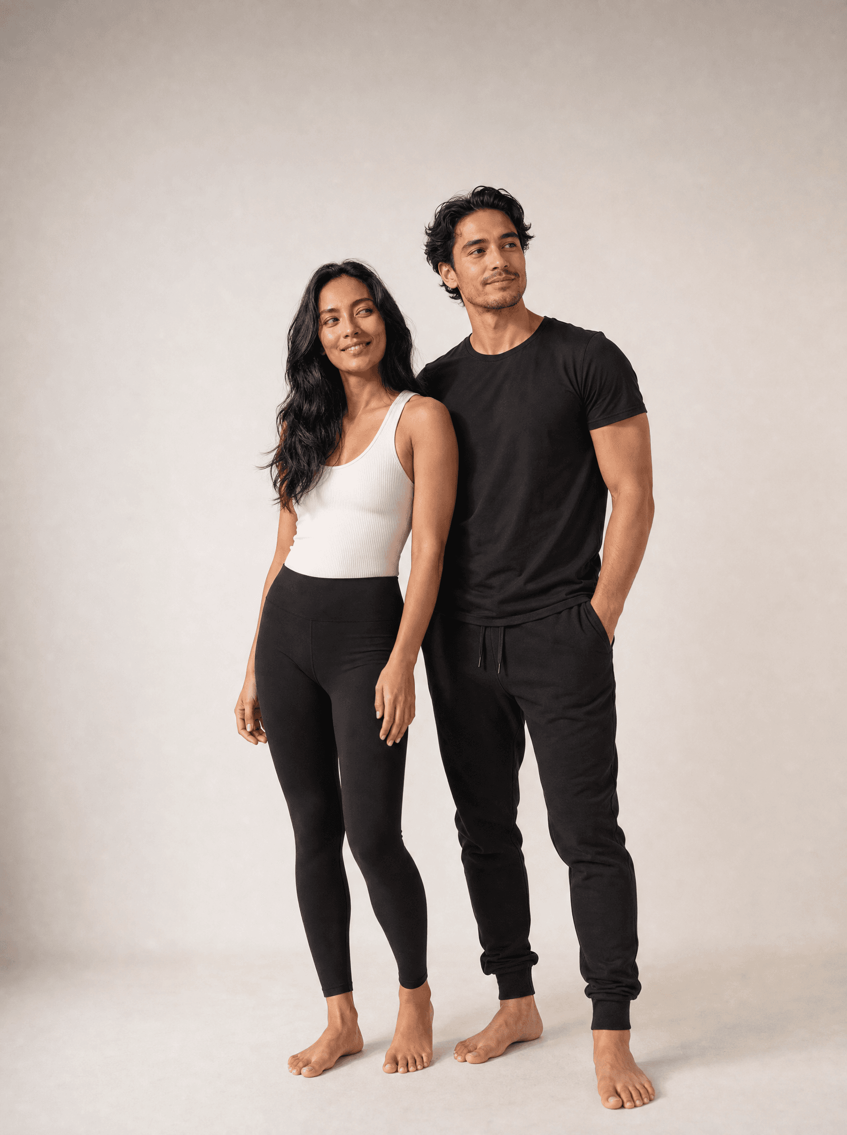 A woman and a man standing relaxed side by side in a warm grey studio